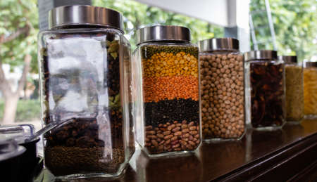 Low angle shot of jars with full of ingredients is kept on table and blur green in the background, food conceptの写真素材