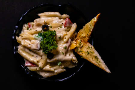 Top view close up of White Sauce Pasta in bowl on black surfaceの写真素材