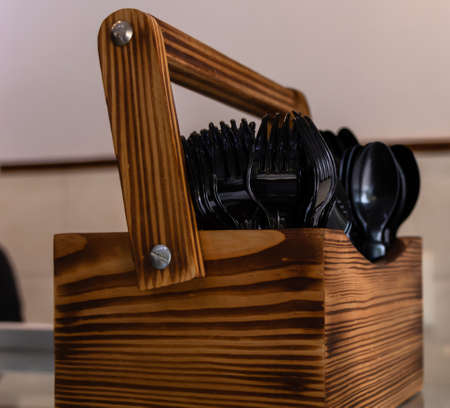 Photography of Wooden Stand with Cutlery Spoon and Forks and blurry in the background.の写真素材