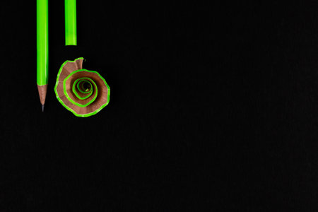 Top view close up shot of two pencils with a shaved one shot over blackの写真素材