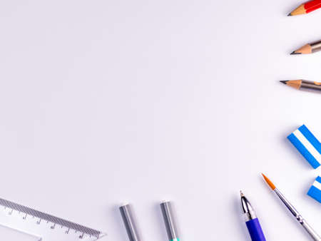 Top shot of pencils, pen and set square in crop view over white paper backgroundの写真素材