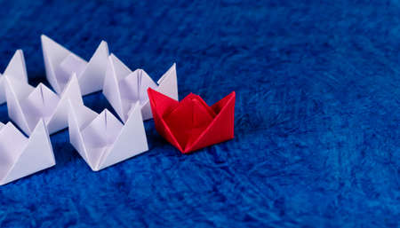 High angle shot of Red & white paper boats in sea made of thick textured craft paper with copy space...