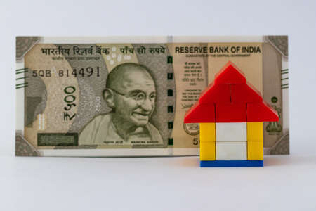 A  house put in front of one five hundred rupee note representing house loan concept