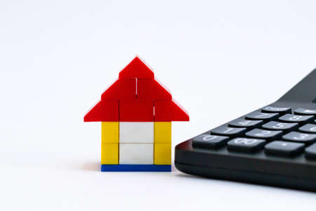 Front close up shot of a toy house with calculator in home loan concept
