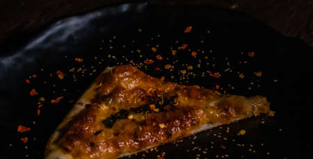 High angle shot of yummy Pizza on black plate
