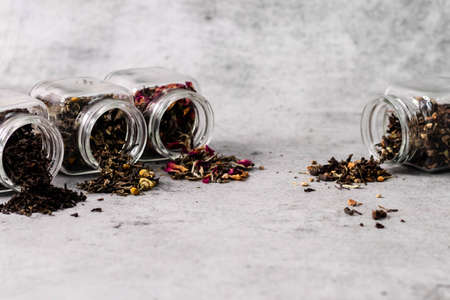 Assortment of dry tea in glass jars with defocused background and copy spaceの写真素材