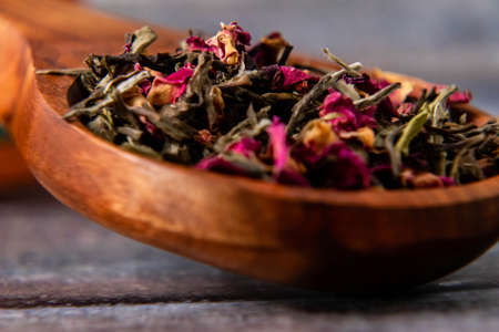 Close up shot of dry rose petals in wooden spoon with defocused backgroundの写真素材