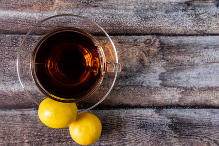 Over the top shot of black tea, lemon on wooden texture with copy spaceの写真素材