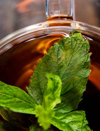Extreme close up shot of mint leaf in black tea with portrait orientationの写真素材