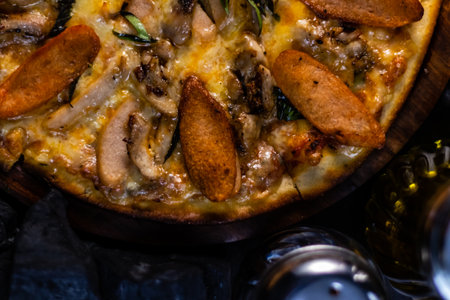 Extreme close up of cropped Chicken Pepperoni Pizza kept on wooden pan.の写真素材
