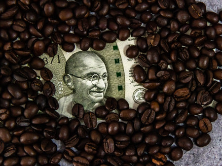 Top shot of indian money covered with coffee beans.