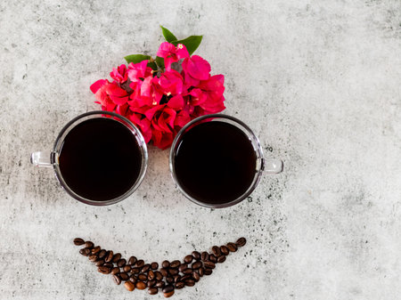 Top shot of black americano,flowers and coffee beans with funny and happy smiling face.の写真素材
