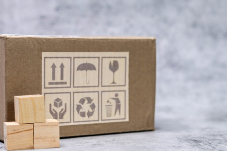 Close up shot of fragile box placed along with wooden cubes on defocused background.