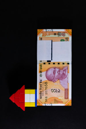 Portrait mode top view shot of a toy house and money notes on black backgroundの写真素材