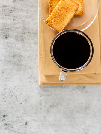Top shot of black coffee with rusk placed on books.の写真素材