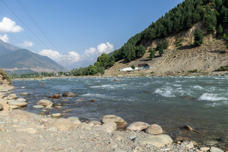 Rocky river bank in the beautiful mountain with cloudy blue sky.
