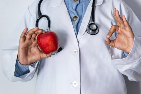Doctor show OK sign with apple.の写真素材