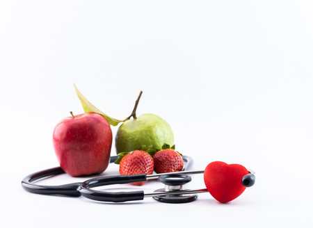 Diet concept with medical stethoscope heart toy and fresh fruits.の写真素材