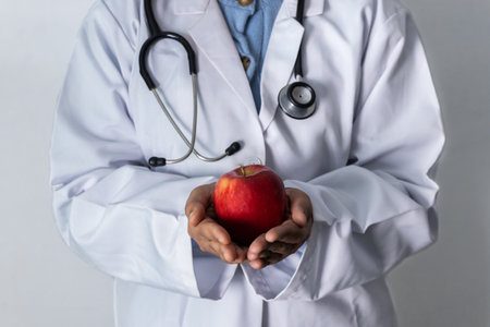 Doctor holding a red apple in her hands - Concept healthy food.の写真素材