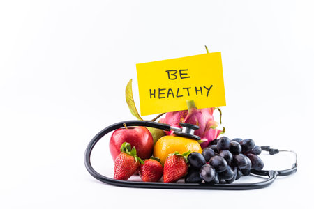 Healthy diet concept with stethoscope and fruits on white background.の写真素材