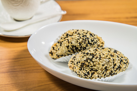 2 pieces of fried dough pastry stuffed with sesame seeds, on a white plateの写真素材