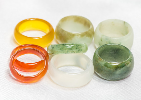 A pile of colored jade rings on cloth background.の写真素材