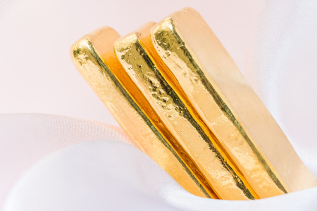 Gold bars gold ingot on a soft pink cloth background. Macro.の写真素材