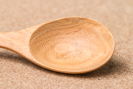 Wooden Spoon made from rubber wood, on the surface of wood background.の写真素材