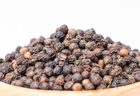 Pile of black peppercorns - black pepper grains on a white background, macro image.の写真素材