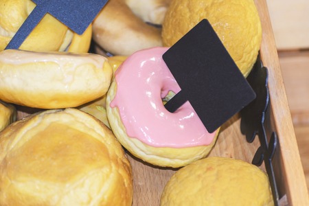 sweet donuts with pink frosting in the box with price tagの写真素材
