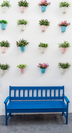 Blue bench with flower pots on background wall のeditorial素材