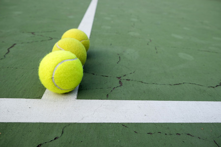 tennis ball on green courtの写真素材