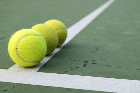 tennis ball on green courtの写真素材