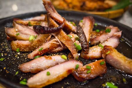 Asian food - slice grilled pork with spicy barbecue sauce serve on iron panの写真素材