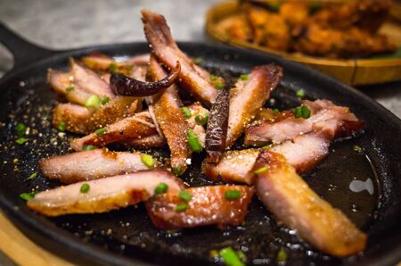 Asian food - slice grilled pork with spicy barbecue sauce serve on iron panの写真素材