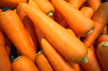 Pile of organic carrot in supermarket, vegetable backgroundの写真素材