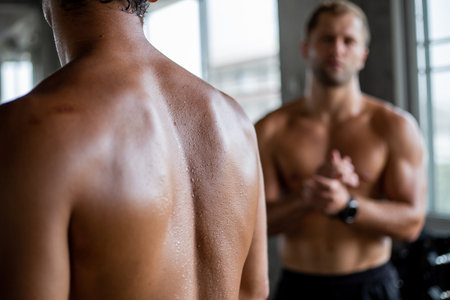 Sweat on muscular back of a man standing in the fitness. Bodybuilding training at gymの写真素材