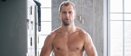 Portrait of Caucasian man showing his biceps muscle at gym fitness studio. muscular strong men workout exercise for better health. people back to normal lifestyle concept with copy spaceの写真素材