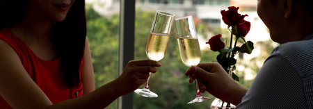 Silhouette couple hand toasting glasses of champagne celebrating on Anniversary, New Year, birthday or Valentine's day. Dinner dating together at home.の写真素材