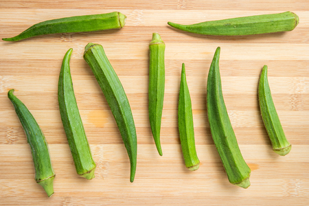 fresh okra on bamboo wooden table. Top view.の写真素材