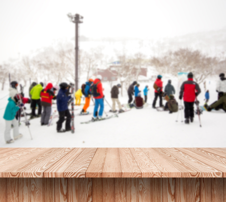 Wood shelf table with blurred background of winter time and many people skiing in ski resort.の写真素材