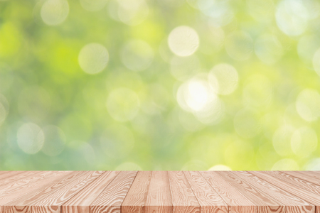 Wood table top on blur green background of trees in the park - can be used for display or montage your productsの写真素材