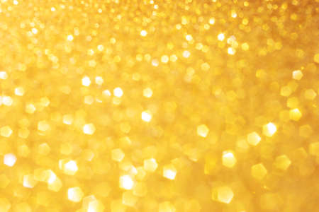 Defocused abstract colorful twinkle light background. Gold glittery bright shimmering background use...