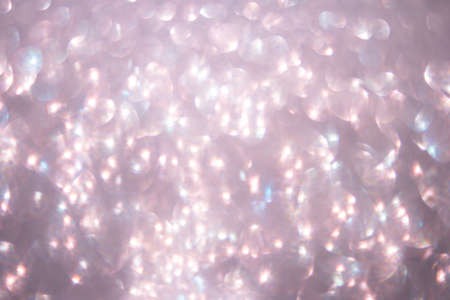 Defocused abstract pink twinkle light background.  Pink glittery bright shimmering background use as...