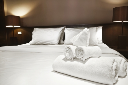 white towels prepared on bed white towels prepared on bed
