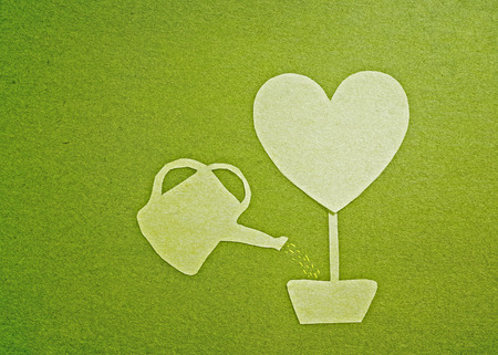 watering a green heart treeの写真素材