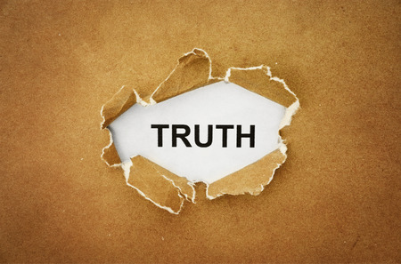 the word  truth  in the hole of brown paper