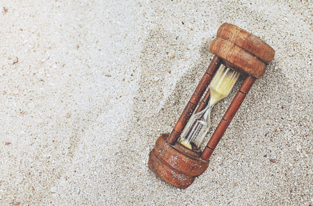 wood hourglass on sandy beach