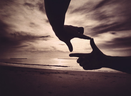 silhouette hand and beach background in retro styleの写真素材