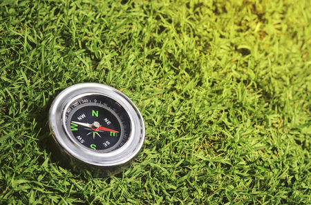 compass on green grass backgroundの写真素材